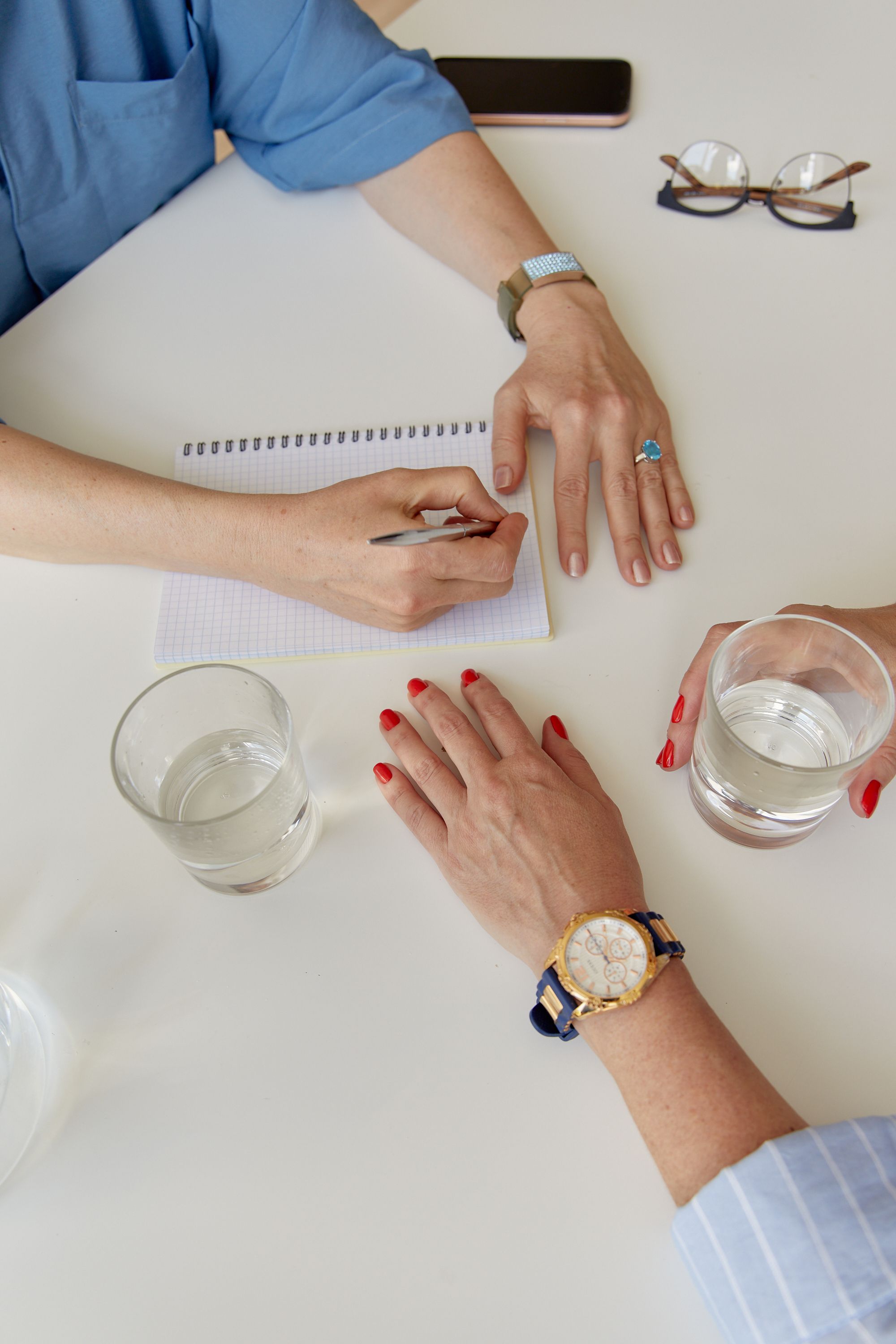 Colleagues taking notes around a table with glasses of water